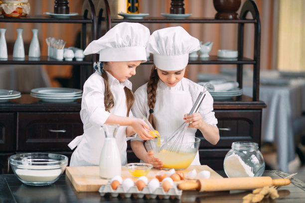 有趣的女孩，孩子们正在厨房里准备生面团。图片下载