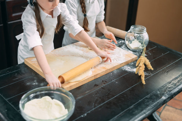 有趣的女孩，孩子们正在厨房里准备生面团。图片下载