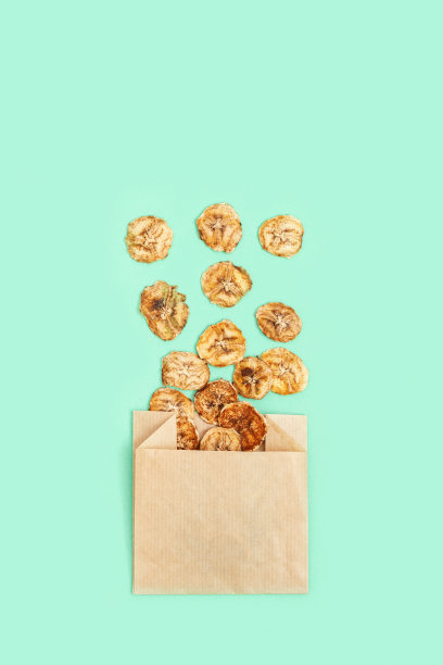 健康的零食。自制香蕉脱水水果片，薄荷色背景。用纸包干香蕉。减肥食品。俯视图和复制空间。图片下载