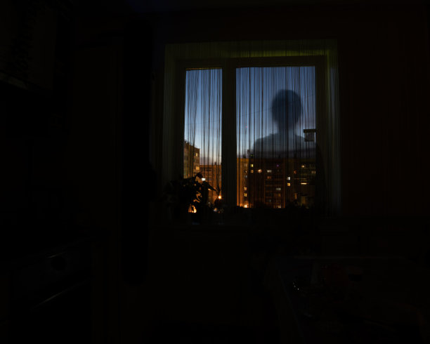 一个人的影子剪影在夜晚的窗户，黑暗的背景，复制空间。危险，孤独的想法图片下载