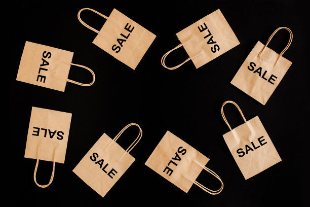 黑色星期五促销打折概念。工艺纸袋与字销售在黑色背景图片下载