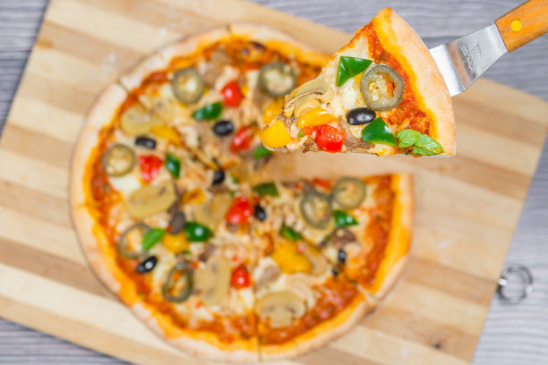 近距离和俯视图鸡肉蘑菇墨西哥辣椒披萨切片从木制砧板。图片下载