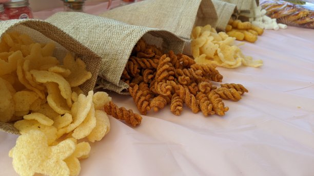 小吃桌。棕色袋子里的油炸意大利面、小麦、花生和薯片零食。图片下载