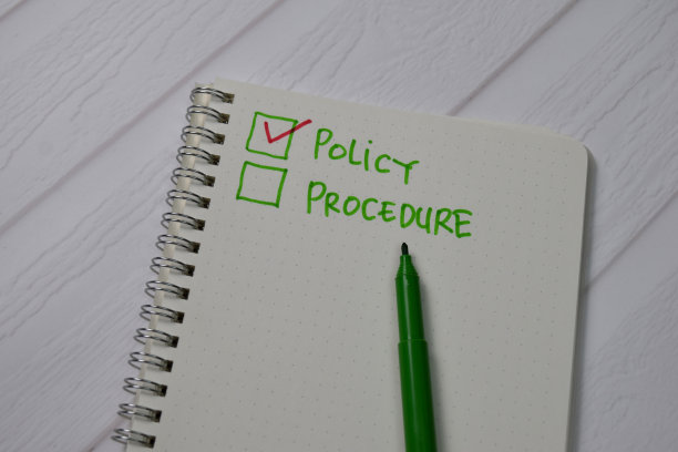 政策和程序写在书里。由一个附加服务的独立木桌支撑。图片下载