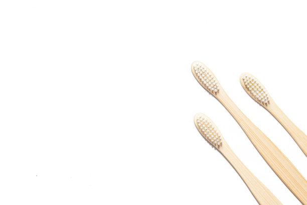 竹牙刷在一个孤立的背景。牙齿清洁。关于选择牙刷的文章。关于牙齿护理的文章。浴室配件。收集度假。天然材料。生态产品。关心环境。副本的空间。图片下载