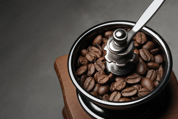 近距离的照片，咖啡豆在手动研磨机在黑暗的背景图片下载