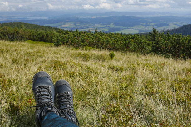 女徒步旅行者在山顶上穿靴子图片下载