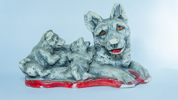 一只狗和小狗坐在一起的家庭雕像图片下载