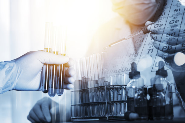 在科学实验室的一项实验中，科学家们把一个化学滴管和元素表放入一个试管中图片下载