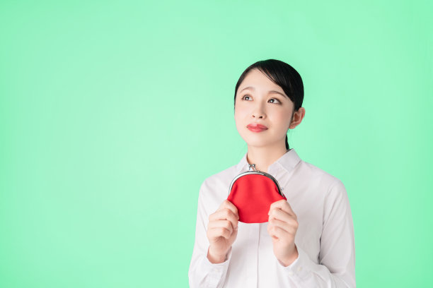 年轻的亚洲女孩拿着一个硬币钱包。图片下载