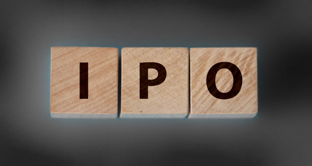 首次公开募股(IPO)，为公司在股票市场上买卖股票，木桌上用字母搭建了IPO字样的木方块，深色的黑色背景图片下载