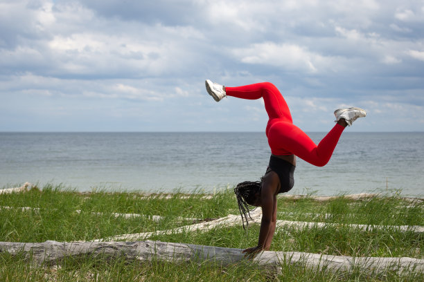 体操运动员在海边练习倒立图片下载