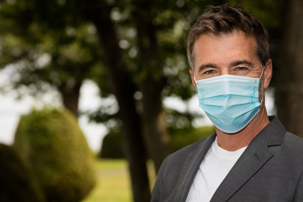 戴着面具看镜头的商业工作者。COVID-19保护的概念图片下载