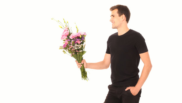 花交付。那家伙拿着一束花孤零零地躺在白色的床上。模拟和复制空间。生日快乐图片下载