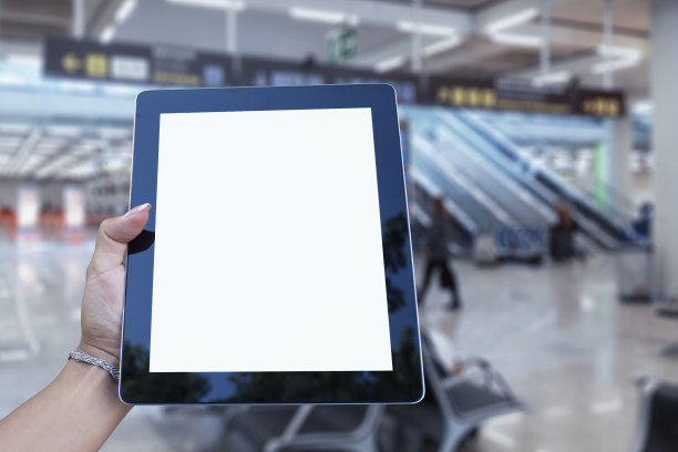 模拟平板电脑在手，机场背景特写。关于航空旅行主题的概念。图片下载