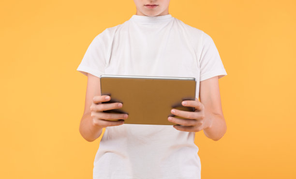 一个面目全非的男孩在工作室里用平板电脑图片下载