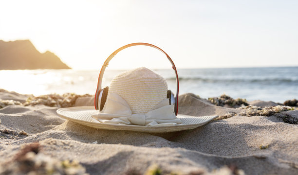 美丽的夏日度假海滩背景与草帽和耳机上的沙背景，边框设计，复制空间图片下载