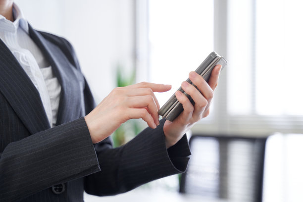 一位日本女商人在办公室使用电话图片下载