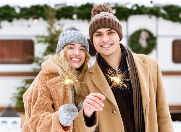这对幸福浪漫的情侣在冬天的户外用孟加拉灯摆姿势图片下载