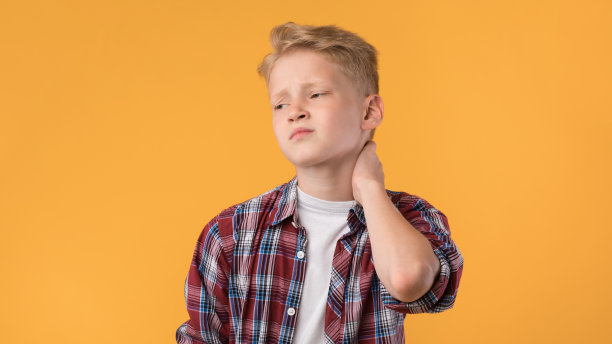 一个疲惫的男生摸着脖子，感觉疼痛图片下载