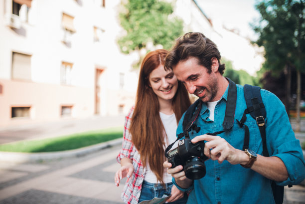 一对夫妇在旅途中看着他们在路上拍的照片图片下载