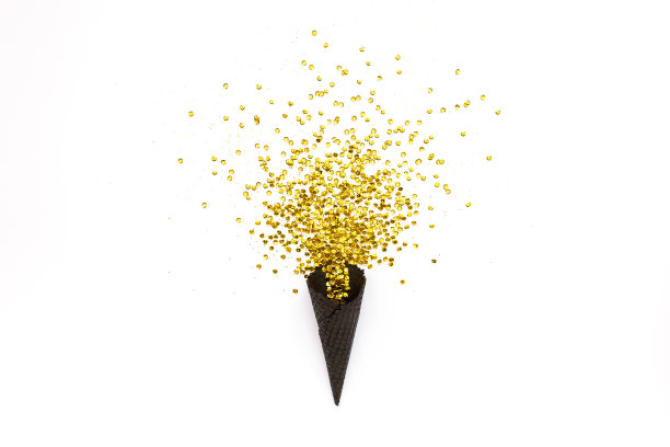 黑色的华夫蛋筒，金色的纸屑点缀在白色的背景上。平铺，俯视图，简约喜庆的概念图片下载