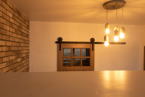 空的桌面和阁楼式的木制推拉门的背景，砖墙和手工混凝土灯。图片下载