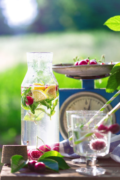 静物-柠檬汁，柠檬，樱桃和薄荷放在花园里的老式木椅上。气氛和情绪“n图片下载