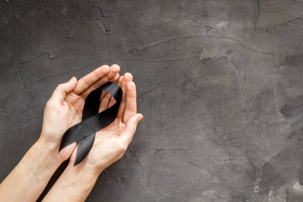 手握黑丝带，俯视图。葬礼的象征图片下载