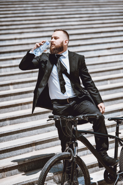 商人骑自行车上班后喝水图片下载