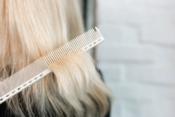 理发师做发型。专业的理发剪刀，工作场所的刷子。专业的美发师工具、设备。理发师的服务。美容院的服务。关闭文本空间。图片下载