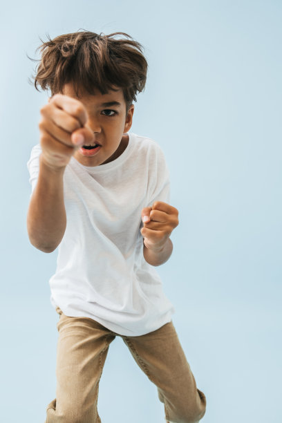 好斗的亚洲孩子用不太合拢的拳头戳摄像机，假装出拳图片下载