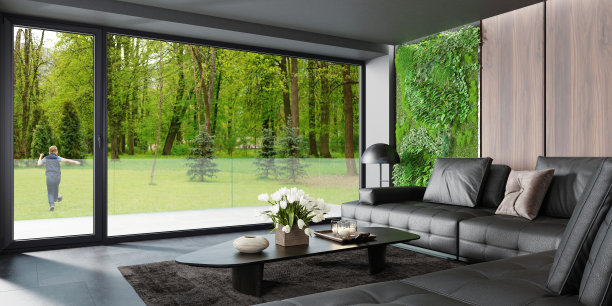 现代乡村别墅客厅内景，配有大型门窗、绿苔和植物墙，以及自然森林背景图片下载
