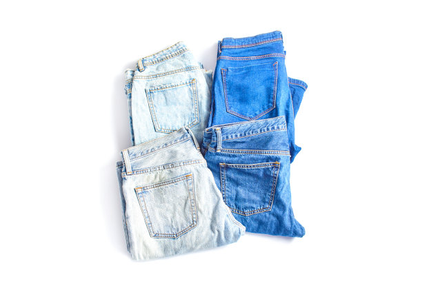 网上购物的概念。白色背景上不同颜色的牛仔裤裤子。简单平铺，俯视图图片下载