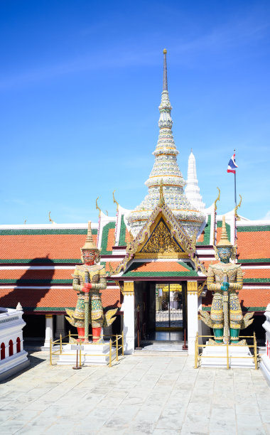 在泰国曼谷的翡翠佛寺，两尊巨大的守护雕像矗立在泰国建筑门前。图片下载