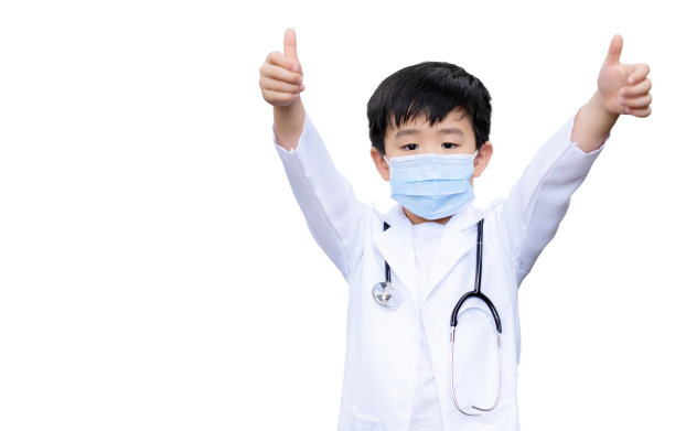亚洲男孩穿着医疗服和防护卫生口罩，并将医生听诊器放在他的颈部隔离在白色背景。一个男孩竖起大拇指，觉得很无聊。教育的概念。图片下载