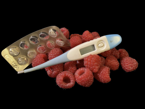 黑色背景上的红色覆盆子和药物。成熟的覆盆子可防治。概念:疾病预防。图片下载