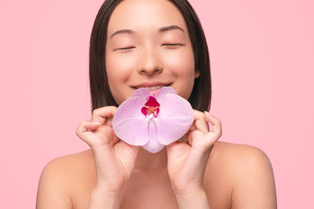 亚洲女人与精致的粉红色兰花图片下载
