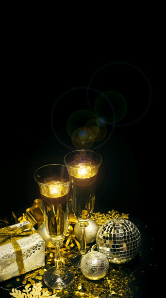金色亮片上的香槟酒杯与礼品盒和迪斯科球图片下载