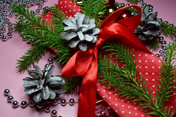 圣诞作文用一个红色的圣诞球和云杉树枝与闪闪发光的银珠子上圣诞老人的红帽子。软焦点,特写图片下载