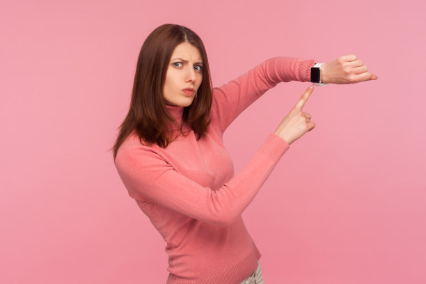 关切准时的黑发女子手指着她手腕上的智能手表，看时间，赶快行动图片下载