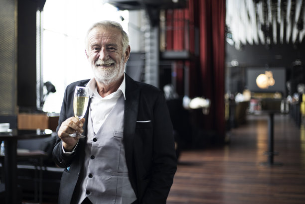 年长的高级行政总裁在餐厅为成功而喝上一杯香槟。图片下载