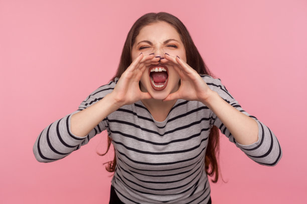 注意,重要的公告!一个穿着条纹运动衫的女人大声叫喊，宣布坏消息的肖像图片下载