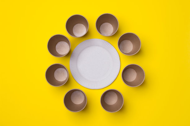在黄色纸背景上创作环保杯子和盘子的照片图片下载