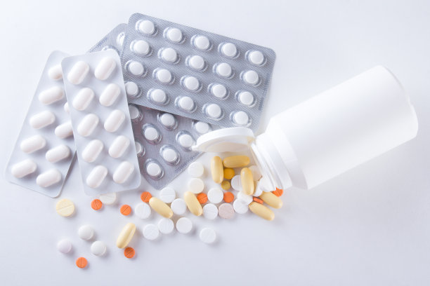 彩色药丸在不同的包装上白色图片下载