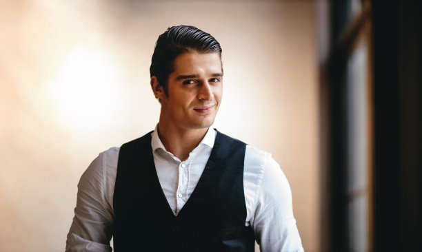 一个微笑的白人商人的肖像，站在窗口，看着相机图片下载