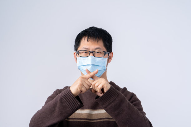 年轻的亚洲男子的肖像，戴着白色背景隔离的医用外科口罩，对冠状病毒感染说不，特写，特写。图片下载