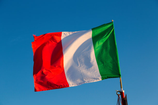 蓝色的天空中飘扬着意大利国旗图片下载