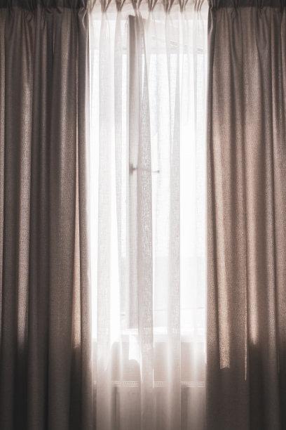 带窗帘的窗户，垂直的。公寓的设计。灰色的窗帘和敞开的窗户。国内的内部。现代家居装饰。图片下载