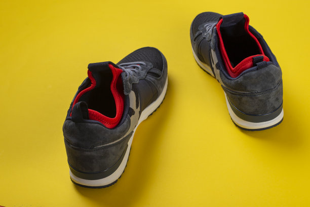 黄色背景上的绝缘运动鞋。温暖的鞋子的概念。图片下载